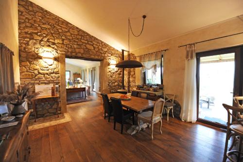 森普罗尼亚诺Agriturismo Sugheretello的一间设有桌子和石墙的用餐室