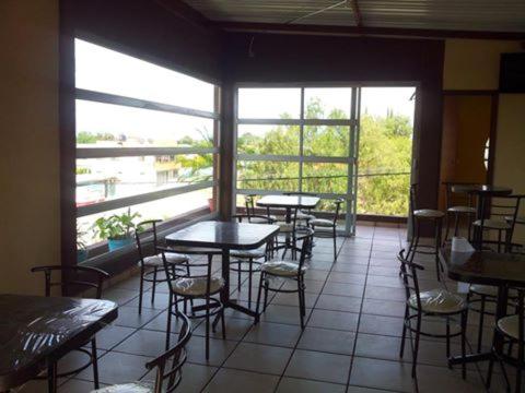 Tezontepec de AldamaHOTEL MONTALVO的餐厅设有桌椅和大窗户。