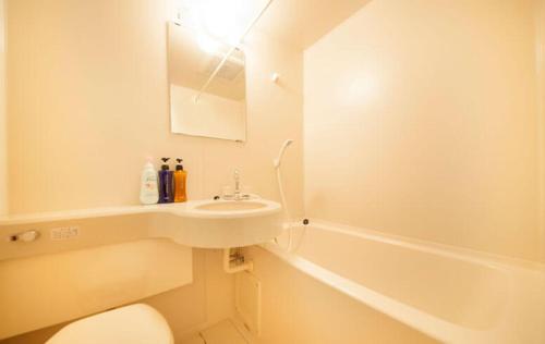 登米市Hotel Bouenkaku的浴室配有盥洗盆、卫生间和浴缸。