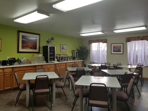 摩押Moab Gateway Inn at Arches Nat'l Park的一间带桌椅的用餐室和一间厨房