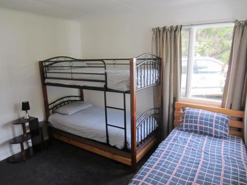 奥福德Orford Escape的卧室设有两张双层床,位于窗户旁
