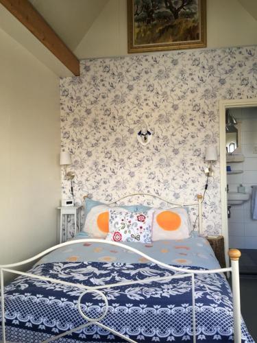 WestzaanHet Pulletje的一间卧室配有一张带花卉壁纸的床