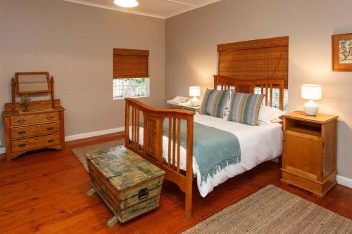 奥茨胡恩Hazenjacht Karoo Lifestyle - Oom Manus se Huis的一间卧室配有一张带木制床头板和一张桌子的床。