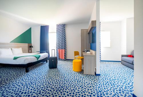 雷庞讷米拉波宜必思尚品马赛康帕捏酒店的酒店客房,带一张床和行李箱