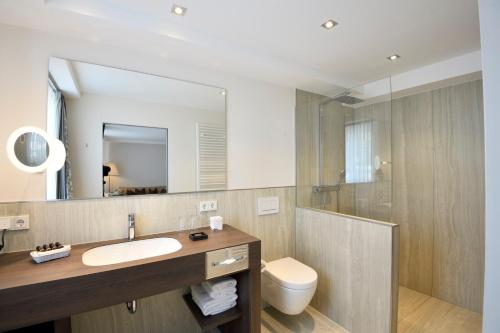 Fuhrbach德尔科龙普林兹酒店的一间带水槽、卫生间和镜子的浴室