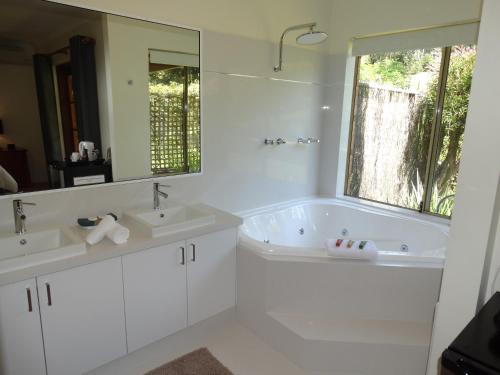 玛格丽特河平达旅馆的白色的浴室设有两个盥洗盆和大镜子