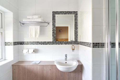 伦敦温布尔登安托瓦内特酒店的白色的浴室设有水槽和镜子