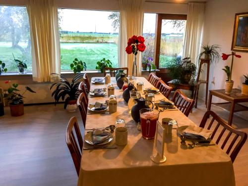 GjerlevShalom的用餐室配有长桌子、椅子和窗户
