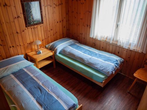 RosswaldChalet Bärgsunna的小木屋内一间卧室,配有两张床