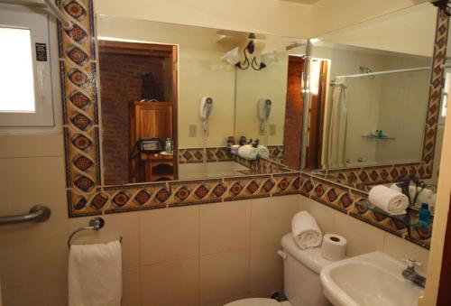 基多古巴别哈酒店的一间带卫生间、水槽和镜子的浴室