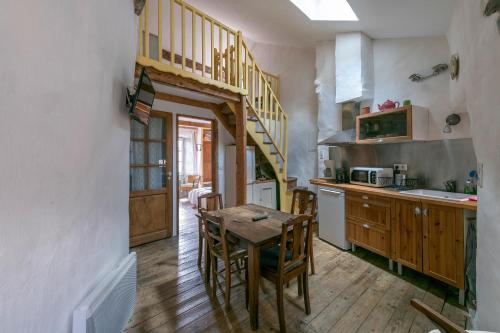 圣莱伊德苏La maison d'Angèle的厨房设有木桌和木楼梯。