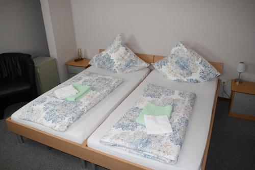 特里尔巴尔干餐厅酒店的客房内的两张床和枕头