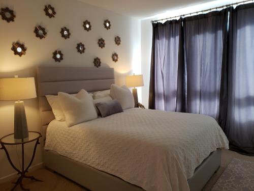 尔湾Penthouse Dreams的卧室配有白色的床和一些窗户。