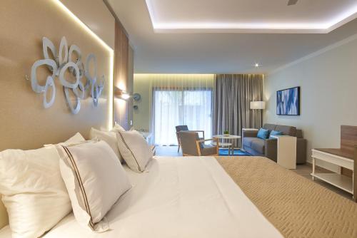 蓬塔卡纳Bahia Principe Luxury Ambar - Adults Only All Inclusive的一间带白色大床的卧室和一间客厅