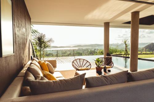 龙目岛库塔Villa Strata的带沙发和游泳池的客厅