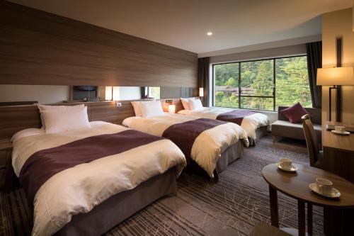 花卷市预感酒店的酒店客房设有三张床和窗户。