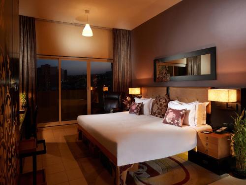 迪拜迪拜兹切公寓式酒店的一间卧室设有一张大床和一个大窗户