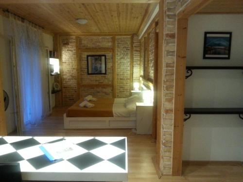 阿查拉维塔索斯别墅酒店的一间卧室设有一张床和砖墙