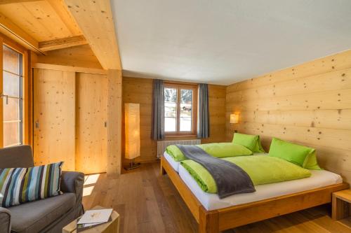 阿德尔博登阿尔卑斯酒店的卧室配有木墙内的一张床
