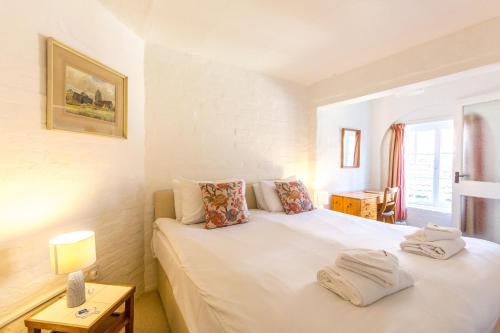 奥尔德堡5 Coastguard Cottages的一间卧室配有一张床,上面有两条毛巾