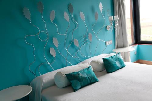 Las Rozas de Valdearroyo阿拉兹酒店的一间卧室配有一张蓝色墙壁的床