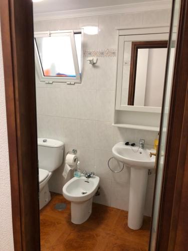 阿里纳加Apartamento playa arinaga的一间带卫生间、水槽和镜子的浴室