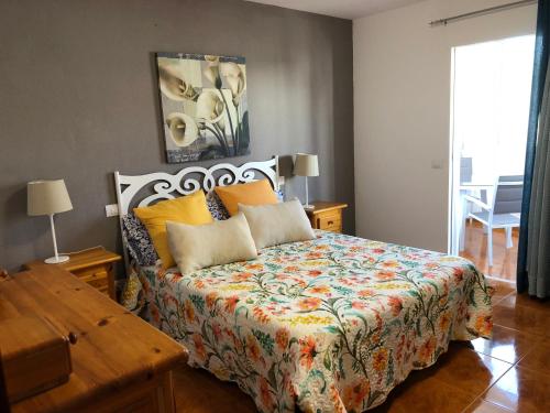 阿里纳加Apartamento playa arinaga的一间卧室配有一张带彩色床罩的床
