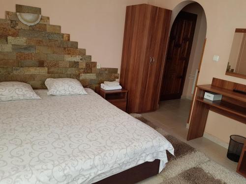 KharmanliOlympia的一间卧室设有一张床和砖墙