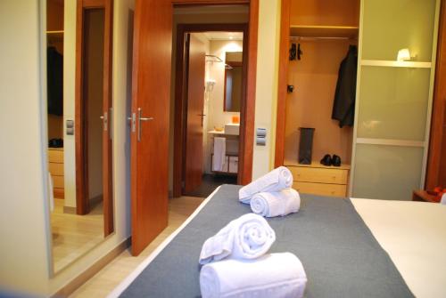 巴塞罗那Apartaments Aragó565的两卷毛巾坐在房间里的床边
