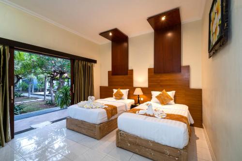 蓝梦岛旁多克岩加拉酒店的一间卧室设有两张床和大窗户
