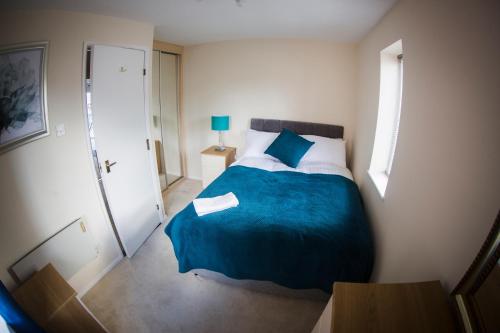 斯旺西Baystays Scenic View的一间卧室配有一张带蓝色毯子的大床