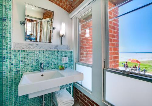 洛杉矶威尼斯微风套房酒店的一间带白色水槽和窗户的浴室