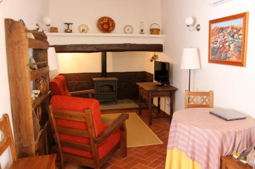 马尔旺Estalagem de Marvão的客厅配有桌子、椅子和炉灶