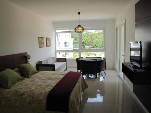 埃斯特角城绿色公园公寓的一间卧室配有一张床、一张桌子和一台电视