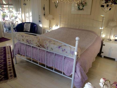 恩斯赫德B&B Het Tuinhuisje的卧室配有白色床和紫色床单