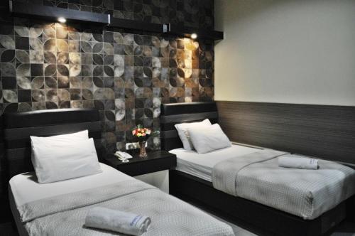 西冷Grand Krakatau Hotel Serang的一间酒店客房,配有两张床和鲜花