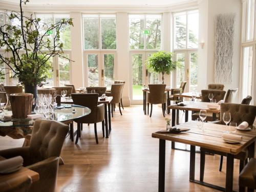 格拉斯米尔Forest Side Hotel的餐厅设有桌椅和窗户。