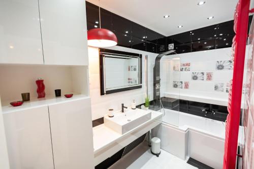 毛科Flame Luxus Apartman的白色的浴室设有水槽和镜子