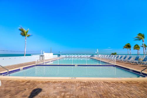 雷顿Fiesta Key RV Resort Standard ADA Room 5的棕榈树海滩旁的游泳池