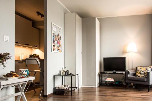 卡托维兹Katowice City Centre Apartment的客厅配有电视、沙发和桌子