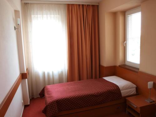 布拉迪斯拉发多米尼卡酒店的一间小卧室,配有床和窗户