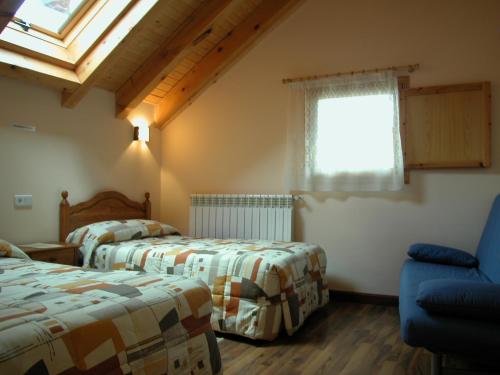 VidángozCasa rural Ornat Etxea的一间卧室设有两张床、一个窗口和椅子