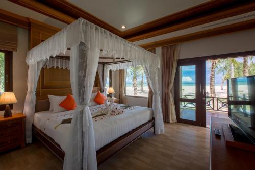阁科考日落海滩度假酒店 - 哥考岛的一间卧室设有一张天蓬床,享有海景