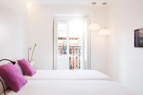 马德里阿奇普酒店的白色卧室,床上配有紫色枕头