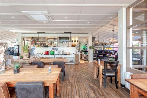 莱利斯塔德鸬鹚餐厅的配有木桌和椅子的餐厅