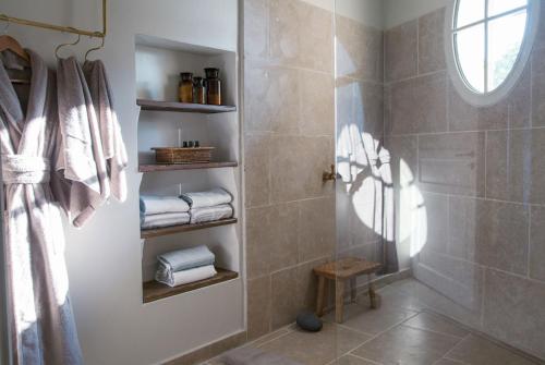 戈尔德Domaine Les Martins - Gordes的带淋浴和毛巾的浴室以及窗户。
