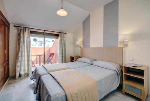 马贝拉Sanpedro Apartamentos Marbella的酒店客房设有一张床和一个阳台。