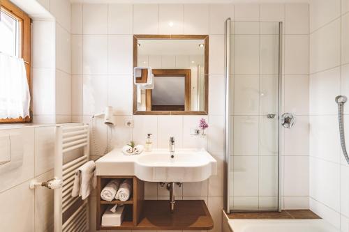 巴特维塞Hotel Garni Gästehaus Brand的白色的浴室设有水槽和淋浴。