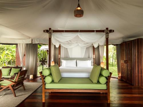 阁遥岛9 Hornbills Tented Camp的一间卧室配有一张带绿色沙发的床