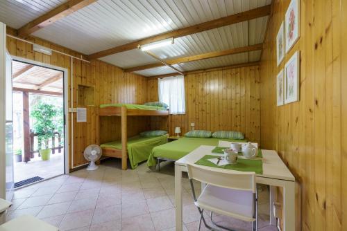 多马索bungalow campeggio madonnina的客房配有双层床、桌子和书桌。